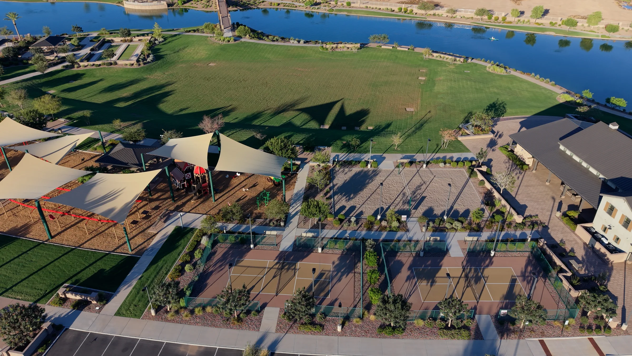 Pickleball courts, sand volleyball, a shaded playground and open event lawn beside the lake at Barney Farms.