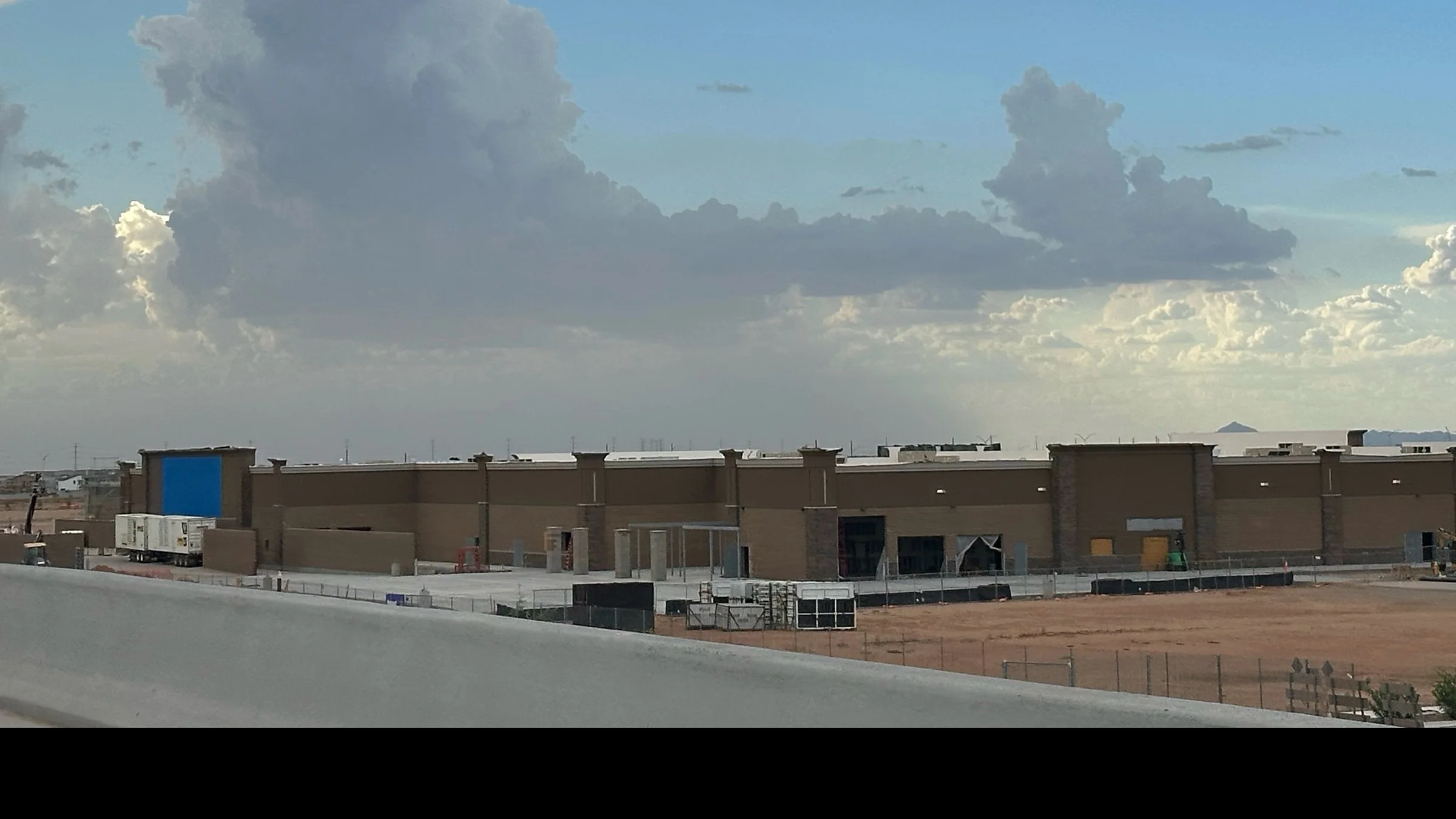 Wide view of the unfinished Walmart storefront and construction area near State Route 24 in southeast Mesa.