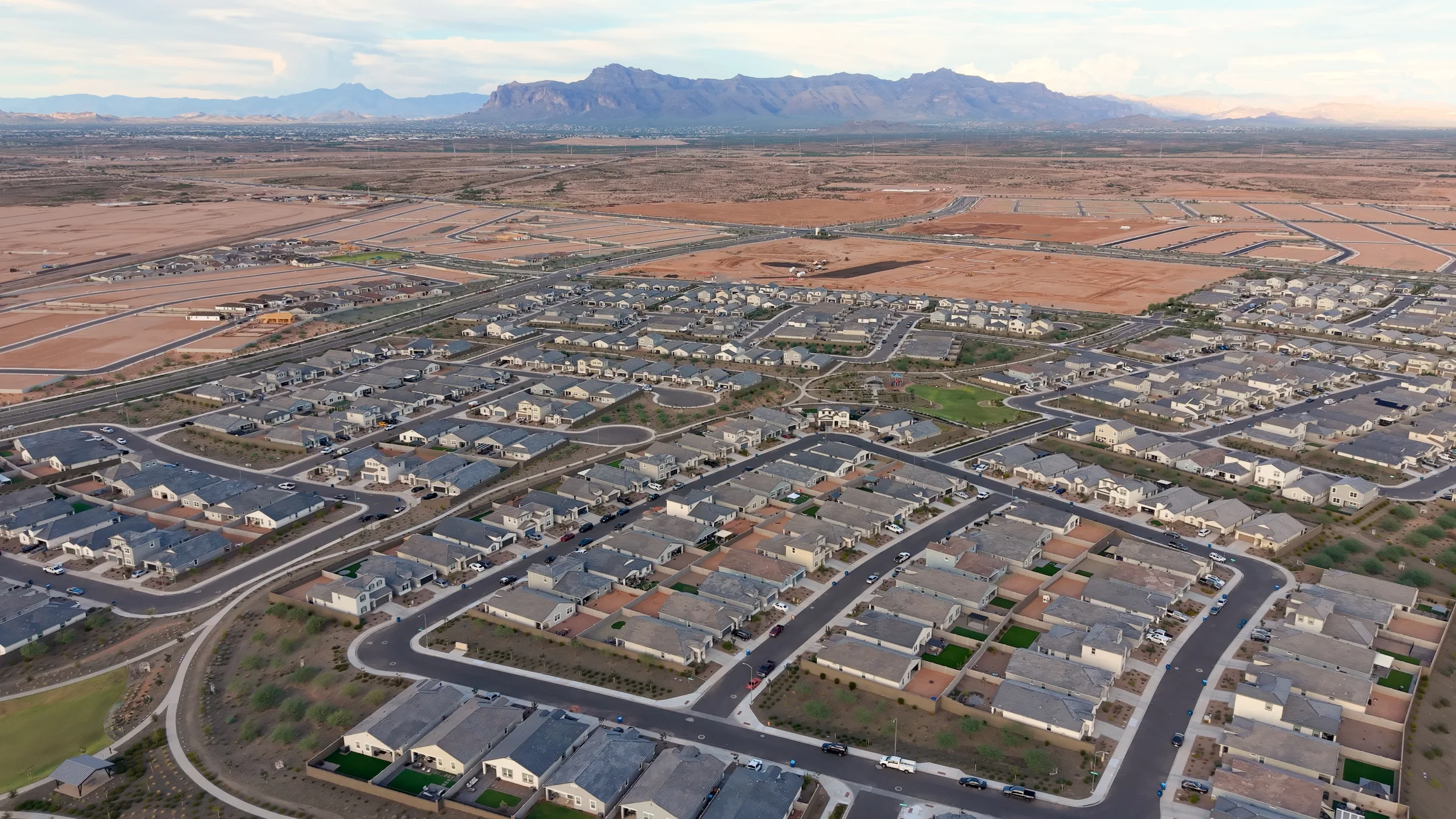Aerial overview of Radiance homes, neighborhood paths and developing streets beneath the Superstition Mountains.
