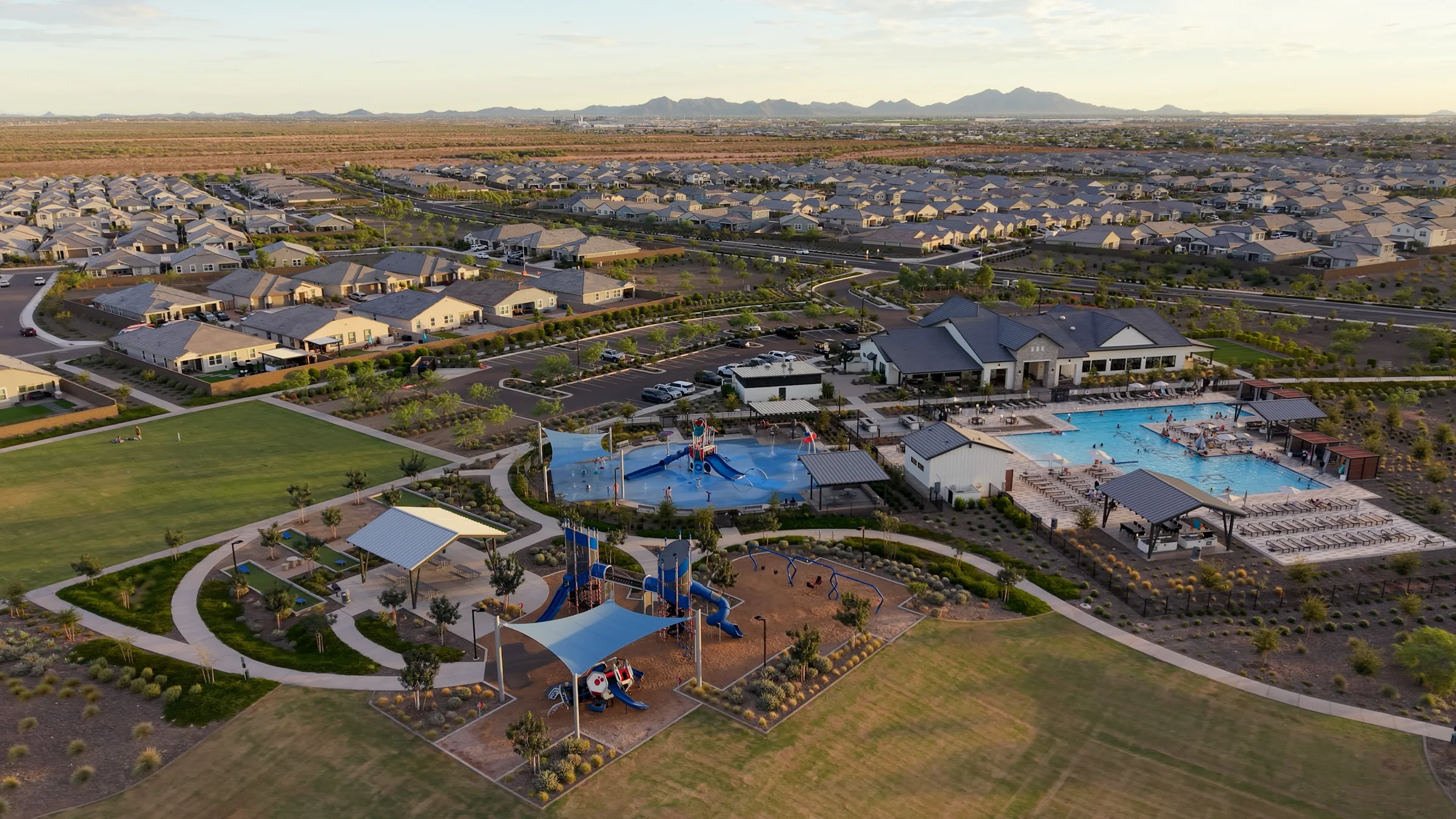 Radiance’s playground, shaded picnic areas, splash pad, pool and open lawns in evening light.