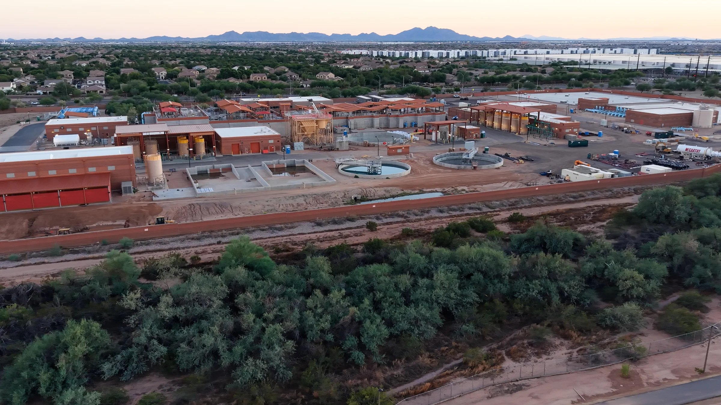 Aerial view of Mesa’s Signal Butte Water Treatment Plant, with red-roofed structures, circular basins and construction equipment near Elliot Road.