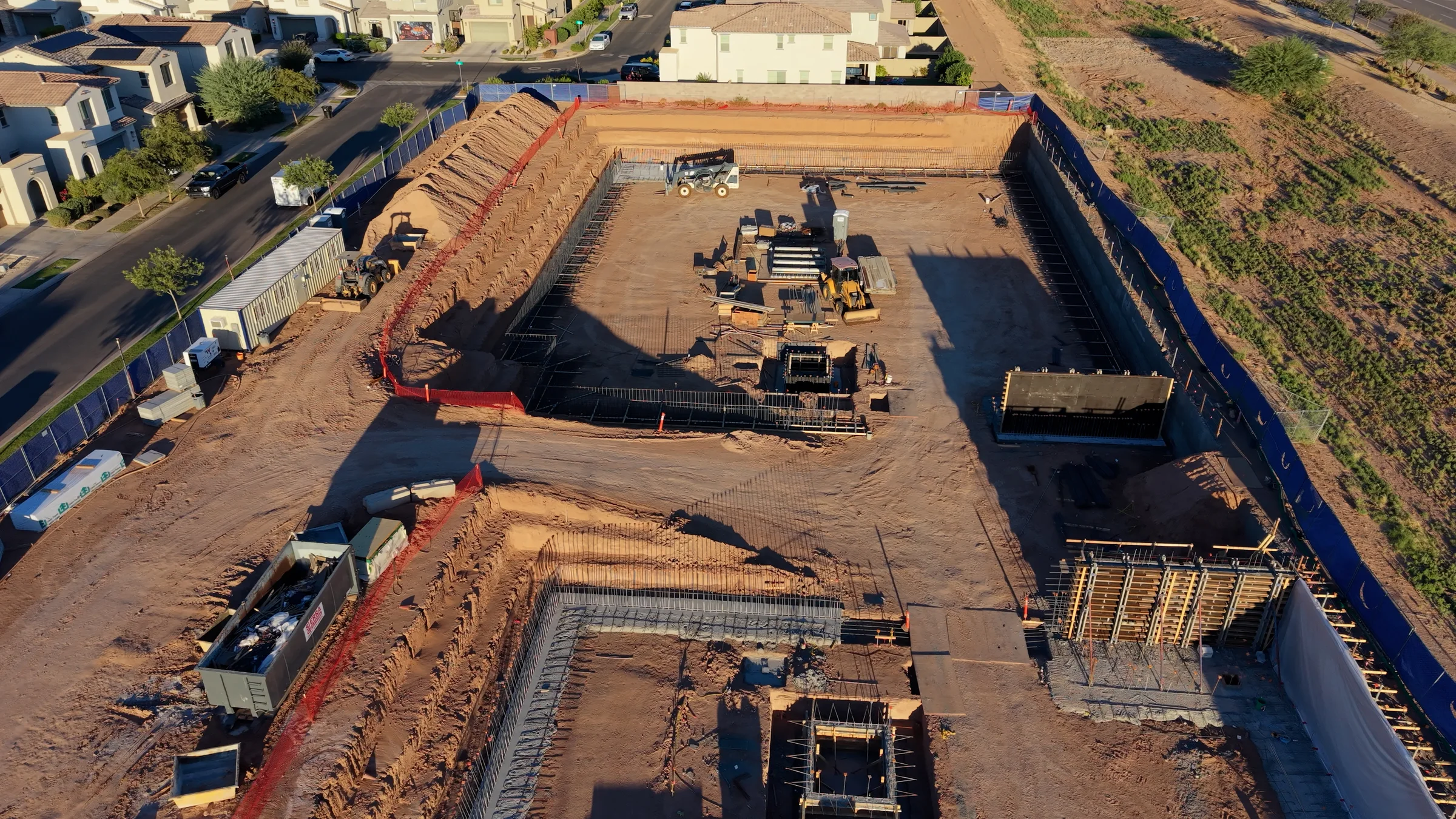 Close aerial view of concrete footings, exposed reinforcing steel and upright wall forms inside the Guardian Storage at Cadence excavation.