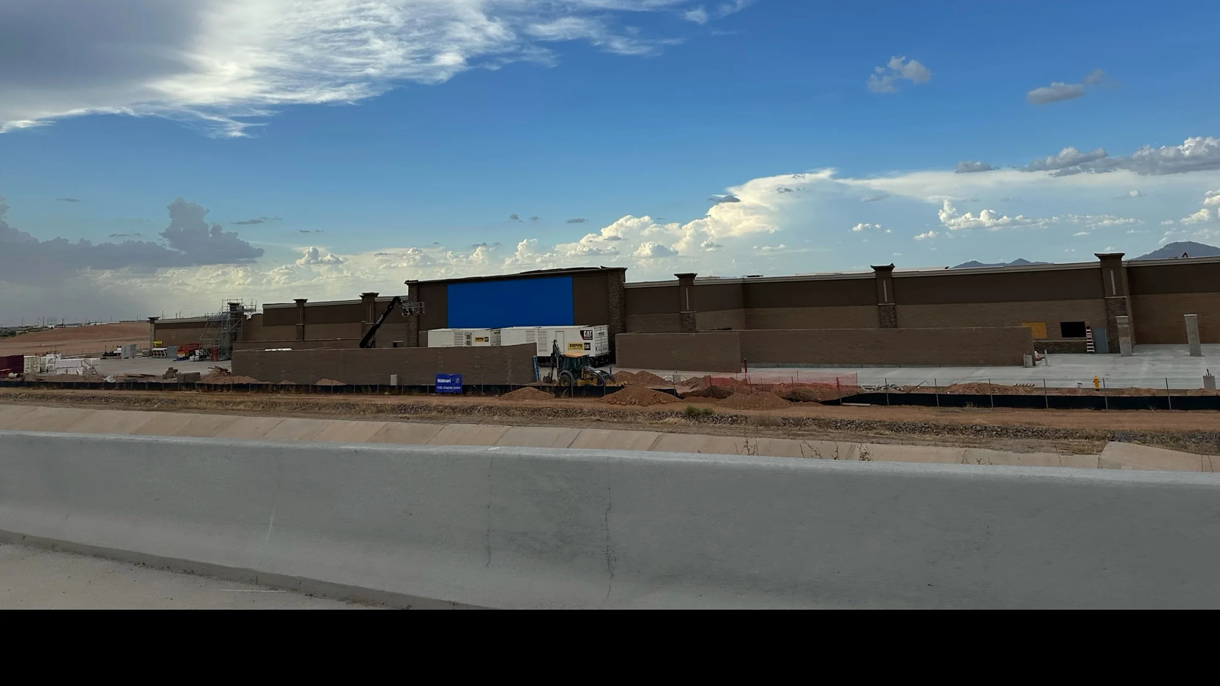 New Walmart Supercenter under construction near Signal Butte Road and State Route 24 in southeast Mesa beneath dramatic clouds.