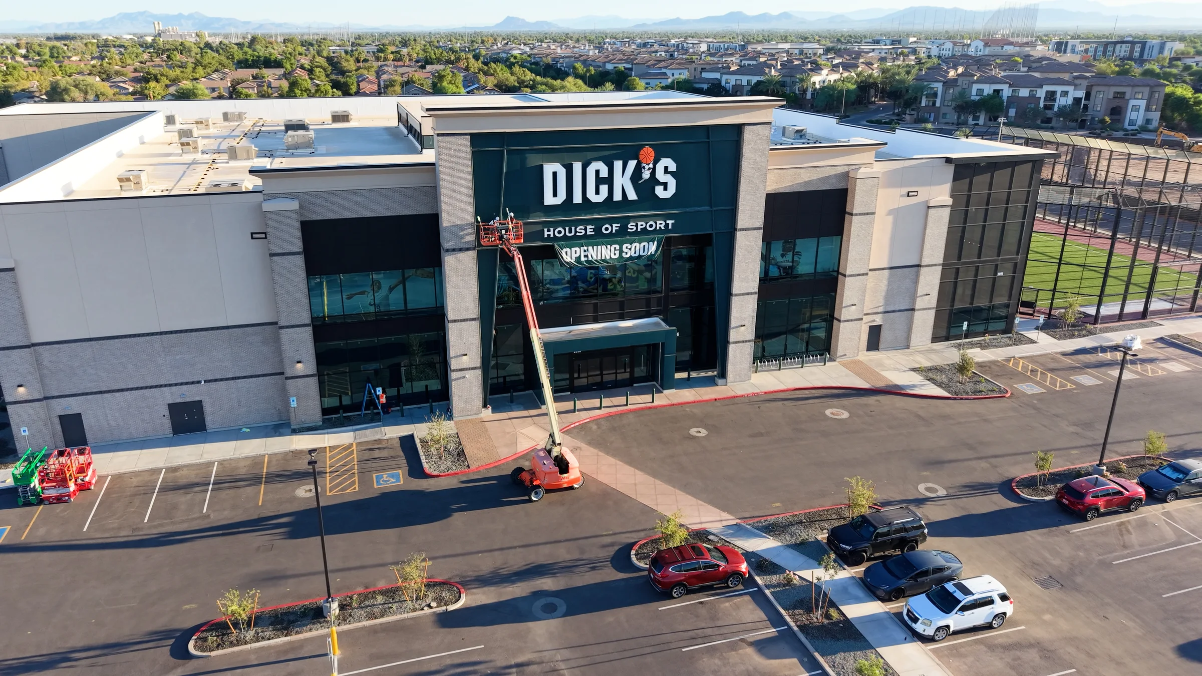 Front entrance of DICK’S House of Sport in Gilbert with an opening-soon banner and construction lift.
