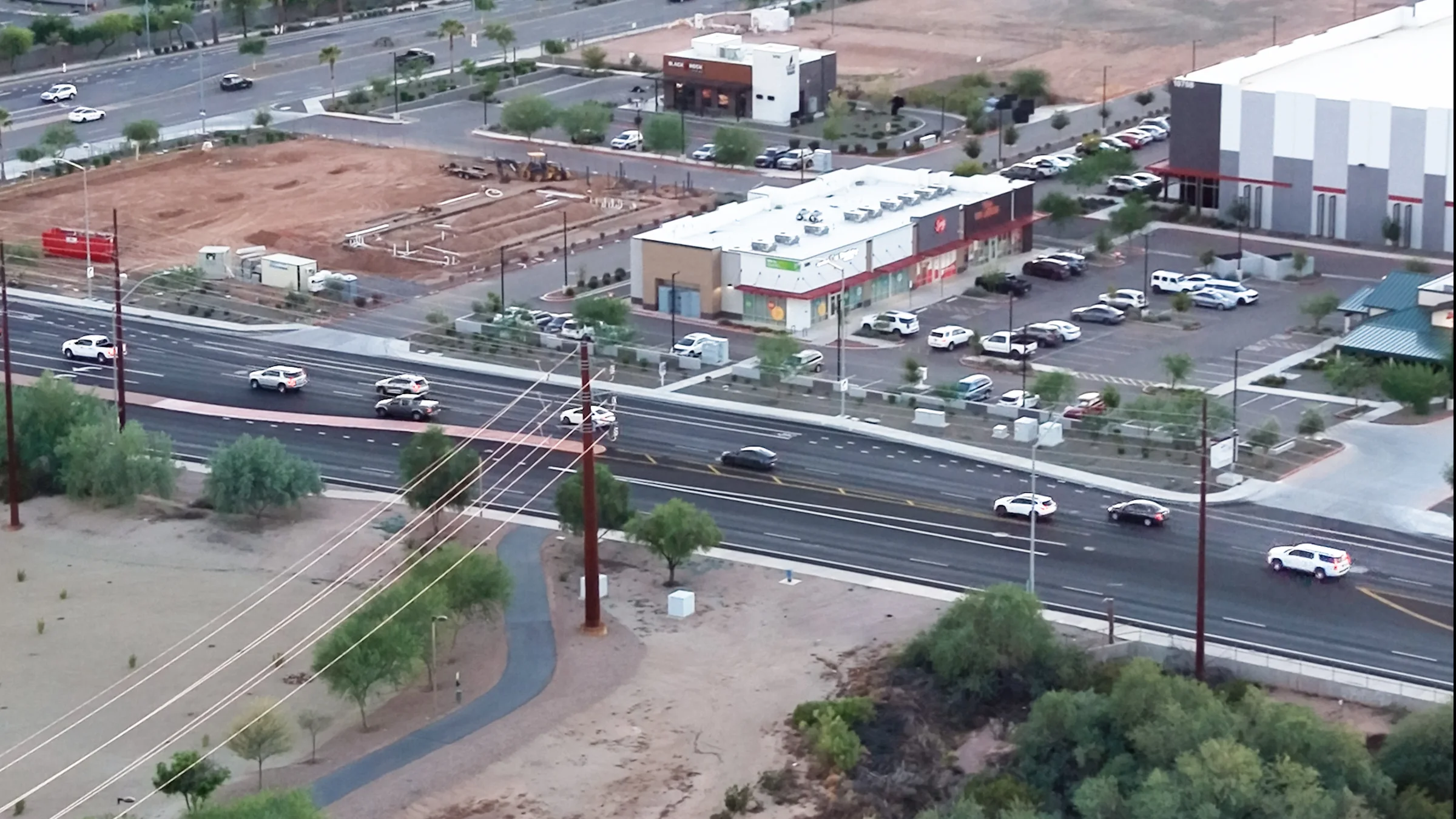 Wide aerial view of the Circle K construction site, neighboring retail strip, Black Rock Coffee and industrial buildings at Elliot Tech Center.