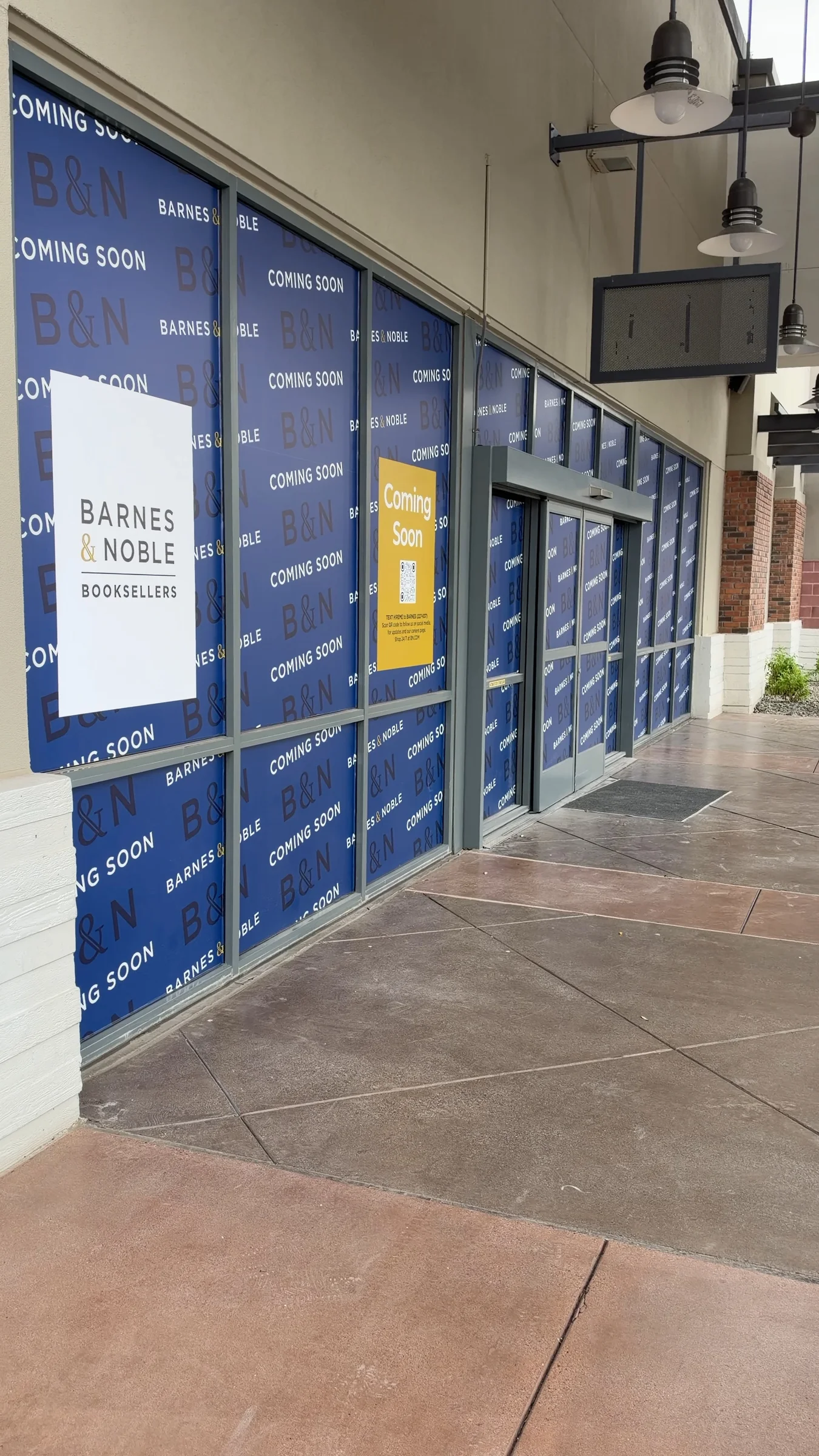 Angled view of the Barnes & Noble entrance at Queen Creek Marketplace, with blue Coming Soon window paper and the bookseller sign.