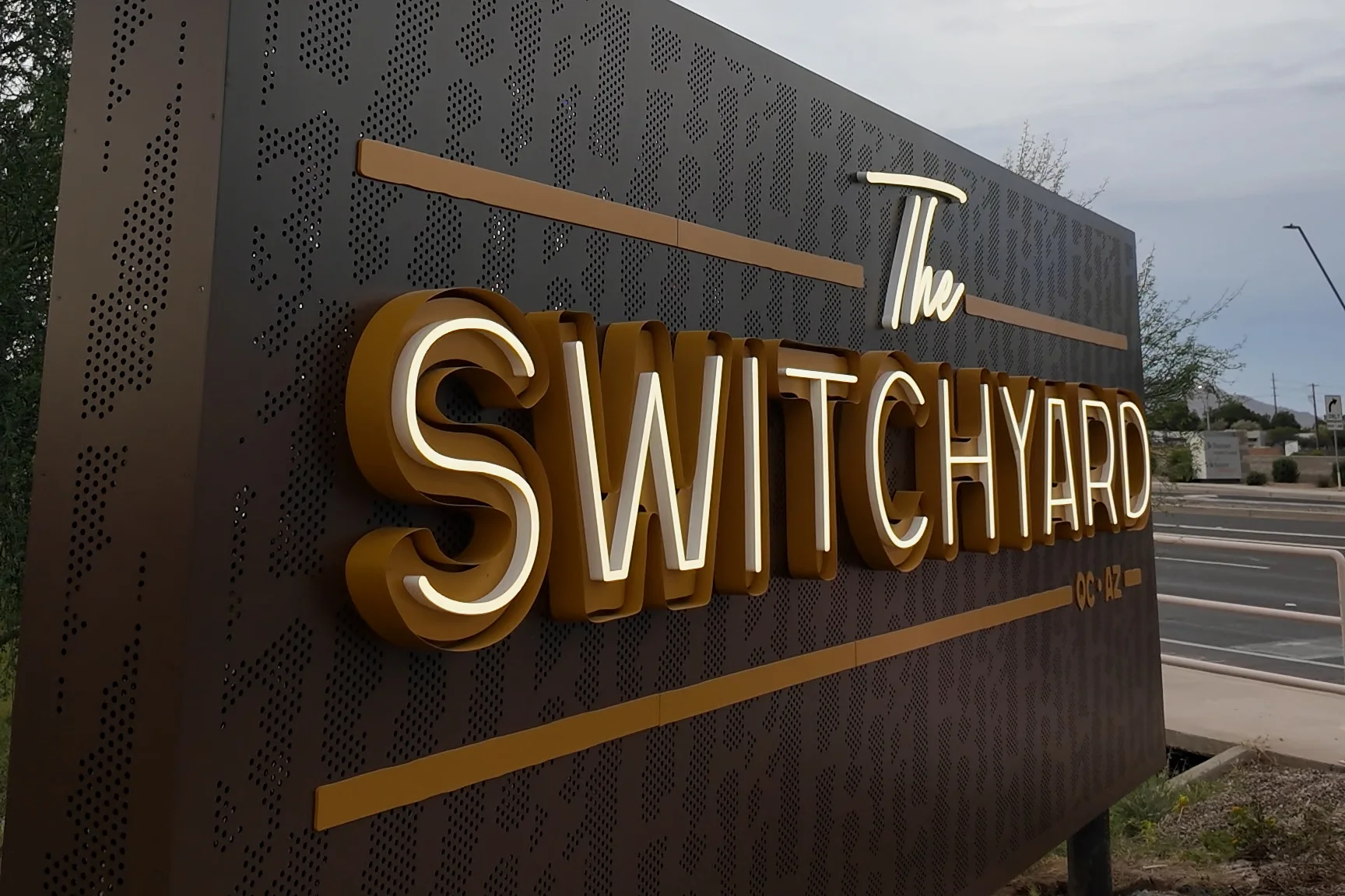 The Switchyard monument sign with illuminated gold lettering in Queen Creek.
