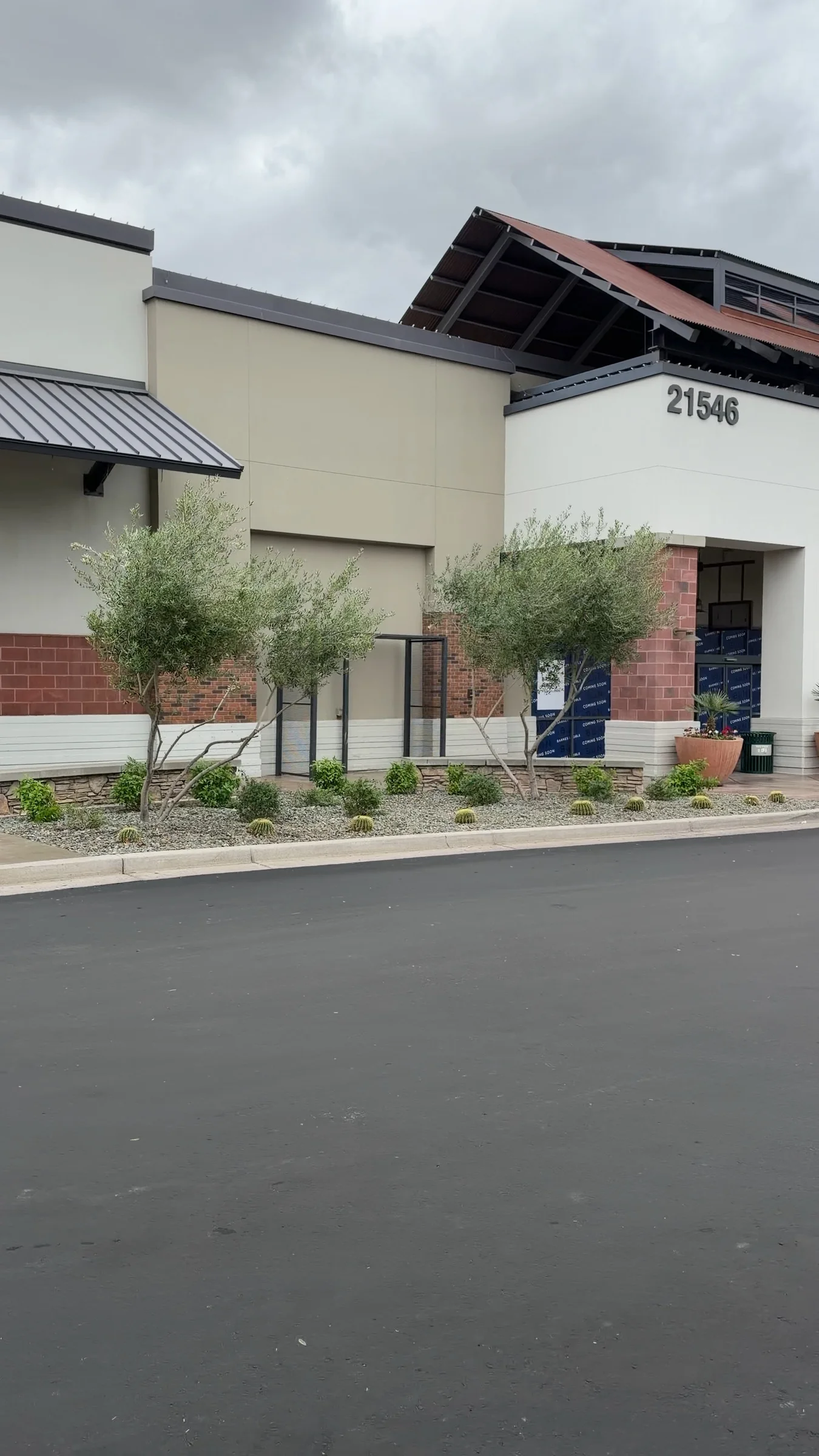 The Queen Creek Marketplace storefront with address 21546 above the covered entrance and Barnes & Noble window paper below.